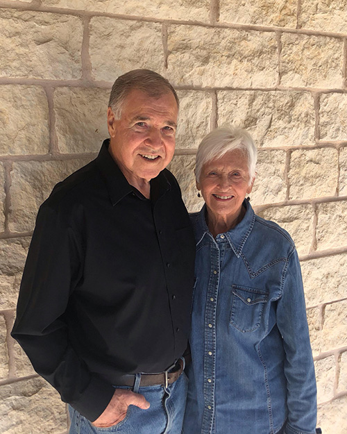 Phil and Betty Roether, standing against a brick wall