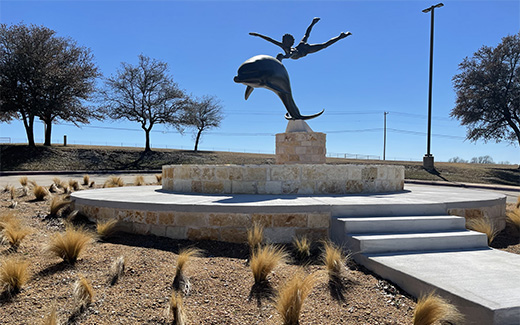 Statue of boy being led by a swimming dolphin