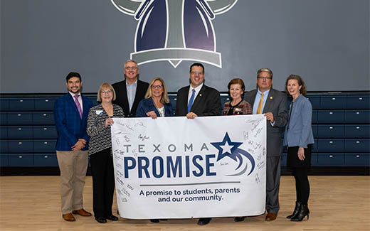 Grayson personnel holding texoma promise banner for photo op