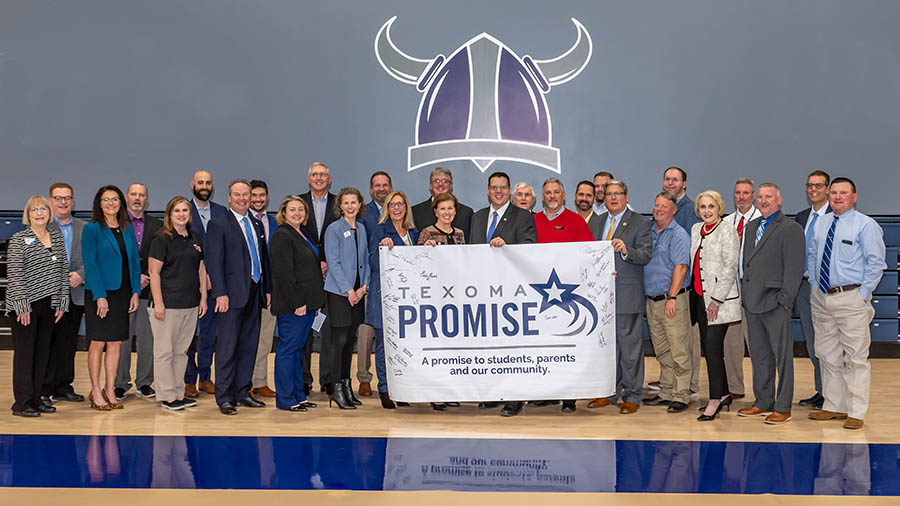 stakeholders holding up signed texoma promise banner